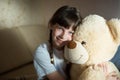 Little girl hugging teddy bear indoor in her room, devotion concept, big bear toy Royalty Free Stock Photo