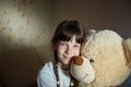 Little girl hugging teddy bear indoor in her room, devotion concept, big bear toy Royalty Free Stock Photo