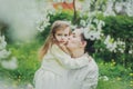 Little girl hugs her mother in the spring cherry garden Royalty Free Stock Photo