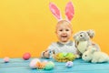 Little girl hugs and kisses Easter bunny on a yellow background