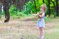 A little girl hugs the teddy bear and makes selfie on her smartphone, a copy of the free space. Summer walk in the forest. Royalty Free Stock Photo