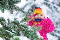 Little girl with icicle in snowy winter park Royalty Free Stock Photo