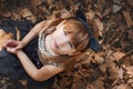 Little girl in the image of cats sitting on dry leaves. Royalty Free Stock Photo