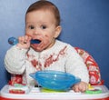 The little girl independently eats with a spoon Royalty Free Stock Photo