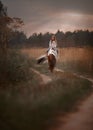 Little girl with in indian style pinto pony in summer field