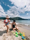 Little girl in inflatable armlets stands on the beach next to her mother Royalty Free Stock Photo