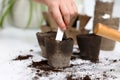 Little girl inserting card with name of vegetable seeds into peat pots at white table, closeup