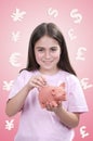 Little girl inserting a coin into a piggy bank Royalty Free Stock Photo