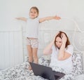 Little girl interferes mom to work at home. Royalty Free Stock Photo