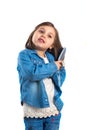 Little girl in jeans with a comb in hand, posing for the camera