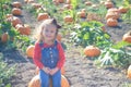 Happy girl sitting on pumpkin at farm field patch Royalty Free Stock Photo