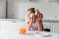 Little girl with juice and fruit apples in the kitchen. healthy food. vegetarianism. the child eats plant food Royalty Free Stock Photo