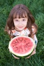 Little girl. Juicy red watermelon. Summer sunny day. Bright grass