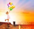 Little girl jump with balloons on the house roof Royalty Free Stock Photo