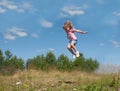 A little girl jumping against the blue sky background Royalty Free Stock Photo