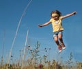 A little girl jumping against the blue sky background Royalty Free Stock Photo