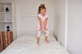 Little girl jumping on bed at home Royalty Free Stock Photo