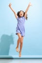 Portrait of winsome little girl,school age kid in summer dress isolated over blue background. Concept of children Royalty Free Stock Photo