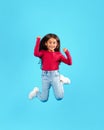 Little Girl Jumping Having Fun Posing In Mid-Air, Blue Background Royalty Free Stock Photo