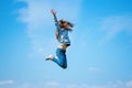 Little girl jumping in nature on a background of blue sky. Happy childhood. A joyful child Royalty Free Stock Photo