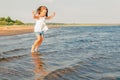 Little girl jumping over a river wave Royalty Free Stock Photo