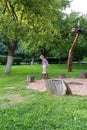 Little girl jumping between stumps in the park