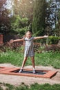 Little girl  is jumping on trampoline in a park. Happy laughing kid outdoors in the yard on summer vacation. Jump high Royalty Free Stock Photo