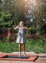 Little girl  is jumping on trampoline in a park. Happy laughing kid outdoors in the yard on summer vacation. Jump high Royalty Free Stock Photo