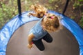 Little girl jumping on a trampoline on a summer day Royalty Free Stock Photo