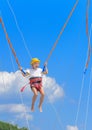 A little girl jumps high on a trampoline with rubber ropes again Royalty Free Stock Photo