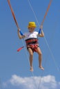 A little girl jumps high on a trampoline with rubber ropes again