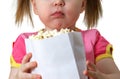 Little girl keeps package with popcorn