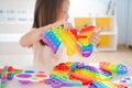 Little girl,kid,child plays with colorful pop it children& x27;s room, bedroom.Funny trendy silicone antistress colorful