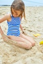 Little kid having fun on the beach and playing with sand toys Royalty Free Stock Photo