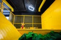 Little girl kid jumping on trampoline at yellow playground park. Child in motion during active entertaiments Royalty Free Stock Photo