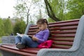Little girl kid reading a book sitting on a bench Royalty Free Stock Photo