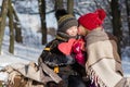 Little girl kissing boy with gift outdoors