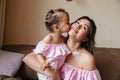 Little girl kissing cheek of her young mother Royalty Free Stock Photo