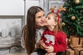 Little girl kissing her mom at christmas photo Royalty Free Stock Photo