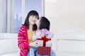 Little girl kissing her mother with gift Royalty Free Stock Photo