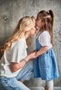 Little girl kissing mother forehead at home. Royalty Free Stock Photo