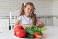 Little girl in the kitchen cutting vegetables Royalty Free Stock Photo