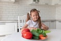 Little girl in the kitchen cutting vegetables Royalty Free Stock Photo