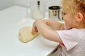 Little girl kneads dough on the kitchen Royalty Free Stock Photo