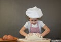 Little girl kneads dough