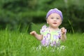 Little girl in a knitted hat sitting on fresh Royalty Free Stock Photo