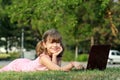 Little girl with laptop lying on grass Royalty Free Stock Photo