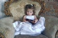 Little girl in a large antique chair