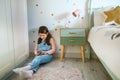 Girl laughing looking at the mobile sitting on the floor Royalty Free Stock Photo
