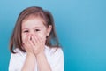 Little girl laughs covering her face with her hands Royalty Free Stock Photo